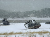 Abandoned Wooden Fishing Boats Sit in a Marsh During a Snowstorm