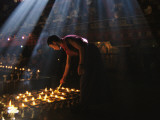 A Buddhist Monk Lights Devotional Lamps Inside Jokhang Temple