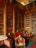 A Red Chair Sits Amid Shelves of Books in Balfour Castle's Library