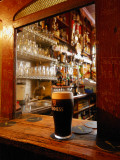 A Pint of Dark Beer Sits in a Pub Service Window