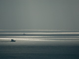 Boats Silhouetted Against a Glittering Ocean