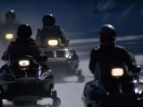 Snowmobilers Ride Down a Snowy Road in Yellowstone Park