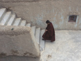 A Tibetan Nun Climbs a Staircase