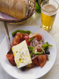 A Greek Salad  a Basket of Bread and Greek Beer