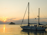 A Sailboat and Bourtzi Castle in Navplion's Harbor at Sunset