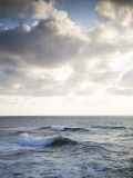 A Lone Wave Breaks as the Clouds Glow at Sunset