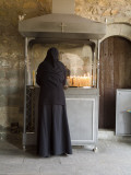 A Nun Lights Candles at a Shrine at One of the Monasteries in Meteora