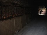 A Pilgrim at the End of a Prayer Wheel Lined Corridor