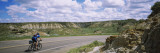 Man Cycling on a Road  Badlands  Theodore Roosevelt National Park  North Dakota  USA