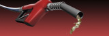 Gasoline Being Splashed from a Gas Nozzle on a Red Background