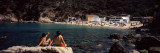 Tourists Sitting on a Rock at the Coast  Aigua Blava  Costa Brava  Catalonia  Spain