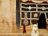 Smiling Monk Walking Towards Entrance to Ganden Sumtseling Gompa (Songzanlin Si) Monastery