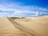 White Sand Dunes Against Blue Sky
