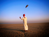Arab Handler Swinging Lure During Hunting Falcon Training Exercise in Desert
