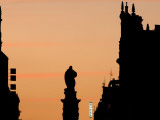Statue of Guzman El Bueno with Illuminated Hotel Sign at Sunset from Plaza Santo Domingo