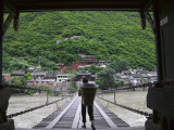 Man Carrying Basket on Luding Iron Chain Bridge over Dadu River