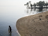 Fisherman with Net in Beach Shallows