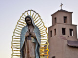 Mother Mary Sculpture with Church Belltower in Background