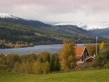 Traditional Wooden Barn with Snowy Fjells in Background