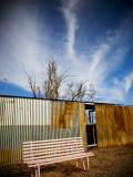 Pink Seat with Corrugated-Iron Fence Behind