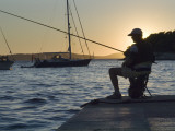 Man Fishing at Sunset at Port