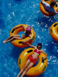 Young Girls Floating in Rubber Rings in Swimming Pool