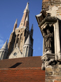Saint Statue Decorating Corner of House with Tower of Church of Our Lady in Background