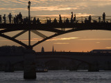 People Silhouetted on Footbridge over River Seine at Sunset