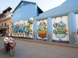 Motorcyclist Passing Night Club with Graffiti Mural
