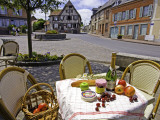 Cheese  Cherries  Apples and Champagne on Cafe Table with Half-Timbered House in Background