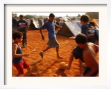 Children Play Soccer Between Tents Placed on a Dusty Lot