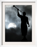 A Statue is Seen against a Cloudy Sky and a Partial Solar Eclipse