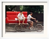 A Chinese Man Rides on a Sofa as Another Pedals a Delivery Tricycle