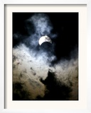 The Moon Partially Covers the Sun Behind the Clouds During a Partial Solar Eclipse