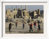 Afghan Boys Play Soccer Near a Mosque and Ruined Buildings During the Early Morning