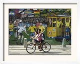 Two Children Ride Their Bicycle Pass a Mural
