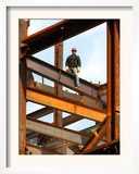 A Construction Worker Stands on a Steel Beam While Working on a High Rise Building