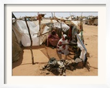 Two Sudanese Women Sit at a Make Shift Hut