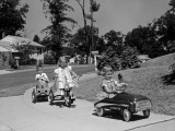 Boy and Two Girls on Suburban Sidewalk  Riding Tricycle and Toy Cars
