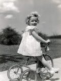 Girl Wearing Summer Dress  Riding Tricycle Down Sidewalk