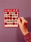 Woman's Hand Crossing Off Final Number on Bingo Card