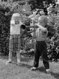Boy Playing Trumpet in Backyard  Girl Grimacing  Holding Hands Over Her Ears