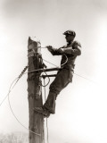 Man Worker  Working Atop Utility Pole  Installing Electric Wires For Power Utilities