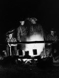 Four Men Wearing Plaid Shirts  Suspenders and Hats  Cooking Over Campfire