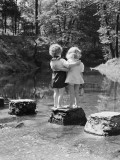 Boy and Girl Standing on Rock Path in Stream  With Arms Around Each Other