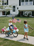 Little Girl With Bugle Leading Girl on Tricycle