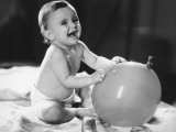 Baby Girl (12-18 Months) Sitting on Bed  Playing With Balloon  Close-Up