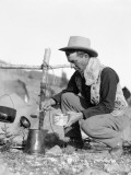 Cowboy Kneeling By Campfire Pouring Coffee