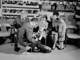 Family in Shoe Shop  Salesman Fitting Shoe on Girl As Mother  Father and Sister Look On
