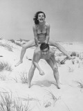 Young Couple on Beach  Woman Leap-Frogging Man  Portrait